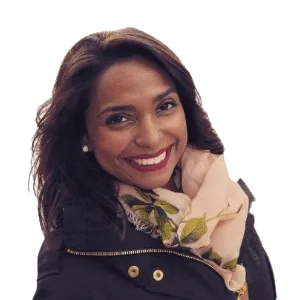 A woman with long, dark hair smiles warmly at the camera. She is wearing a black jacket with a button detail and a light-colored scarf with green leaf patterns. The background is transparent.