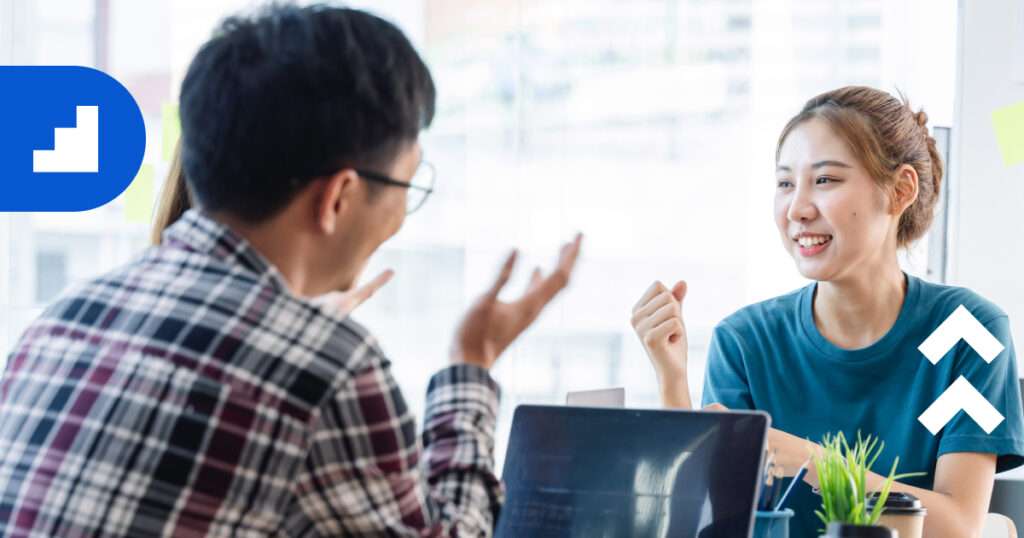 Two startup team members discussing strategy with a consultant in a bright office, symbolizing how expert advisors help startups grow and avoid failure.
