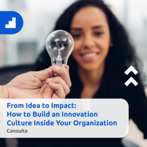 Close-up of a person holding a clear light bulb in focus while a smiling woman in the background looks on, symbolizing new ideas and innovation. Text overlay reads: ‘From Idea to Impact: How to Build an Innovation Culture Inside Your Organization – Cansulta.