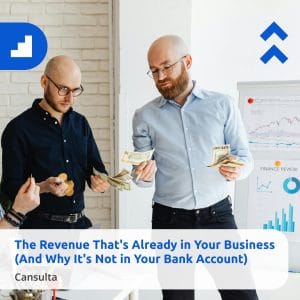Two men in an office count revenue beside a whiteboard with charts and graphs. One holds dollar bills and a notebook, while the other has coins. Overlay text reads “The Revenue That's Already in Your Business (And Why It's Not in Your Bank Account)” with Cansulta Branding.